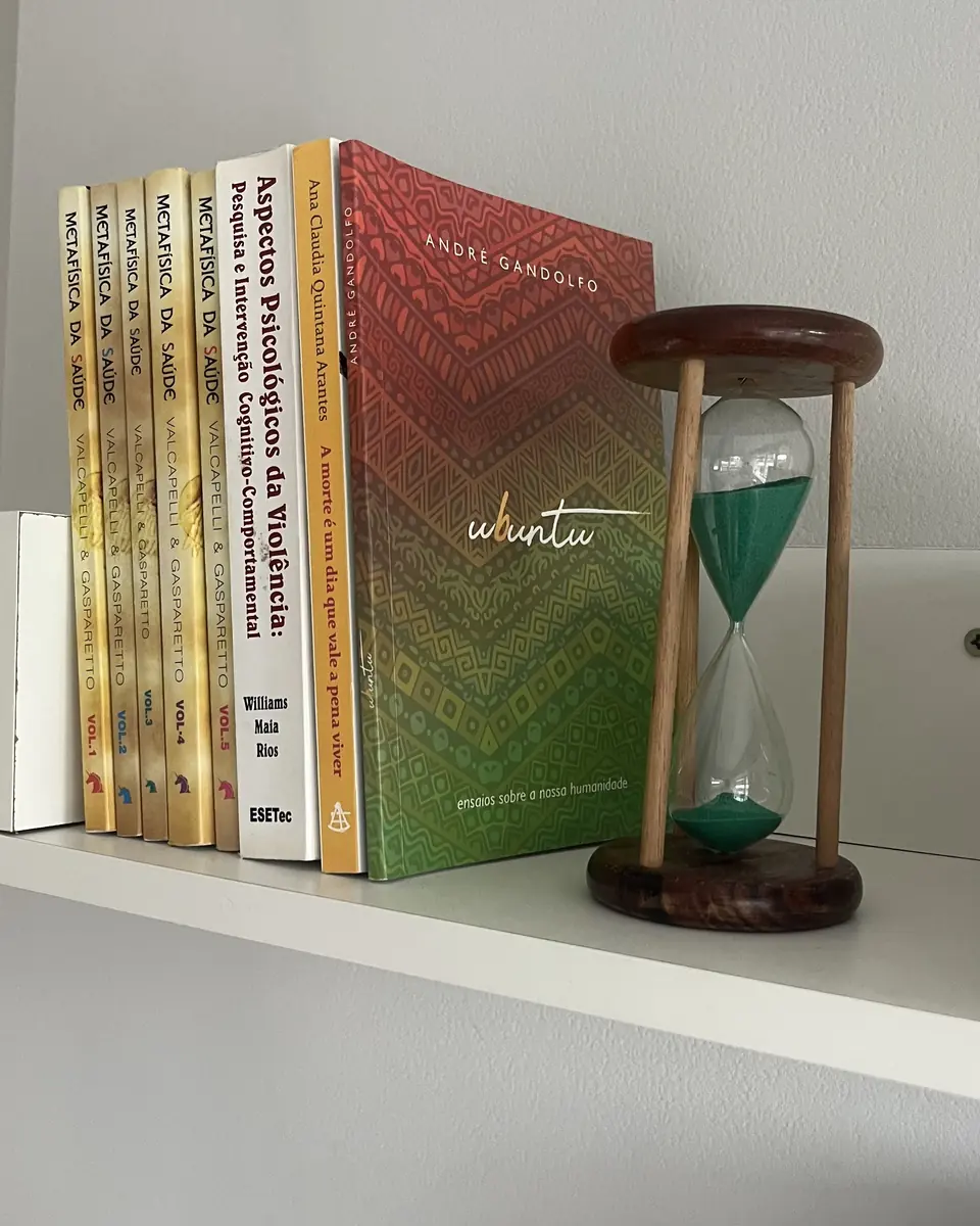Livros e ampulheta na prateleira