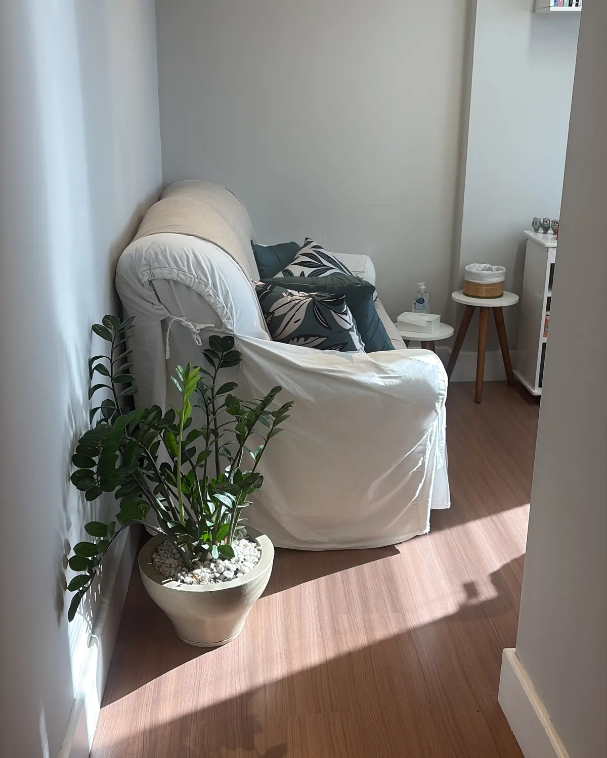 Sala de atendimento com poltrona branca, planta e luz natural
