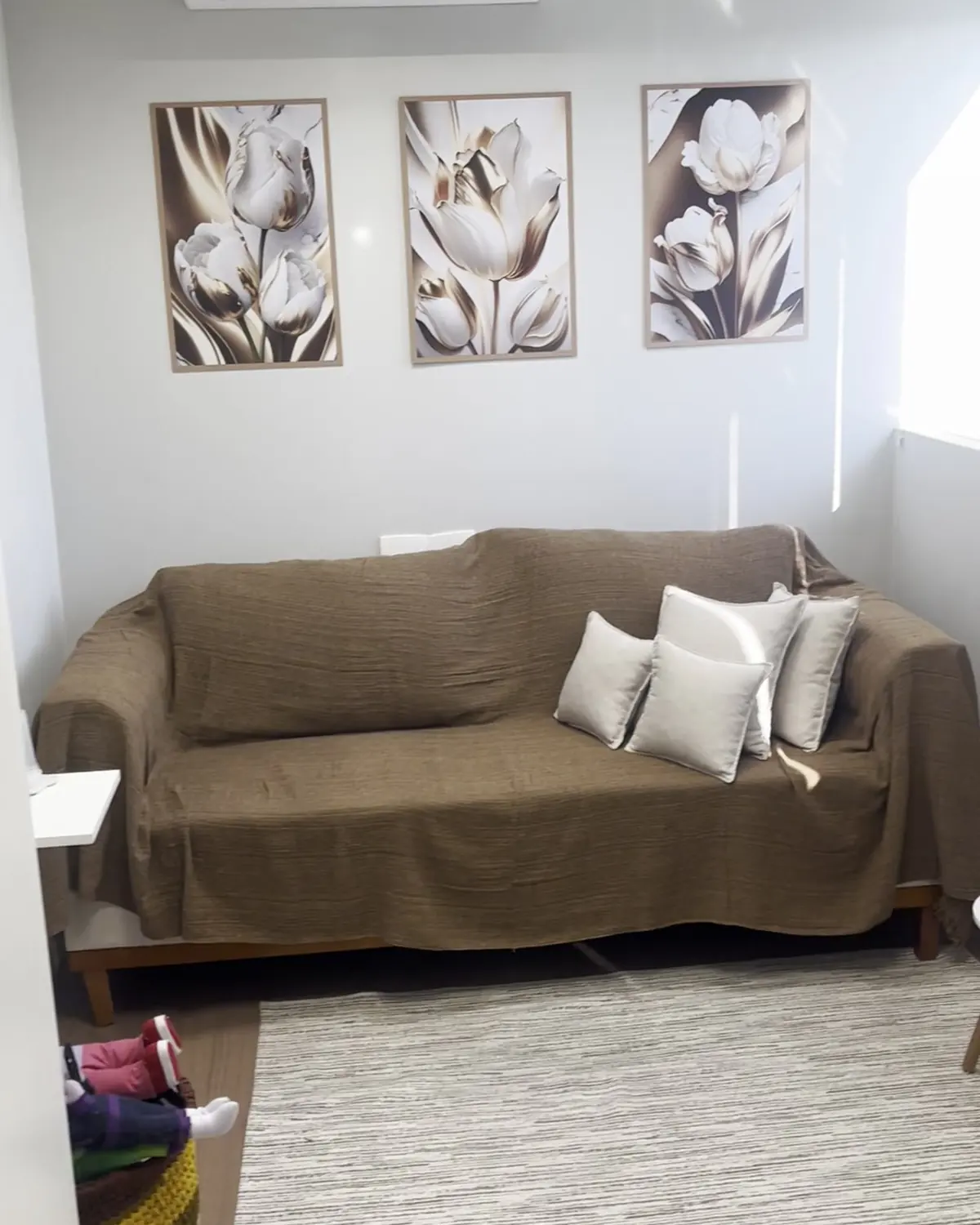 Sala de atendimento com sofá e quadros de tulipas